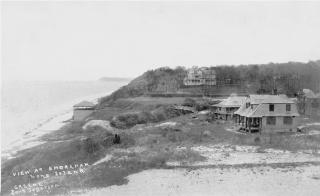 View of the sparse coastline with waterfront houses and a beach pavilion built into the bluff